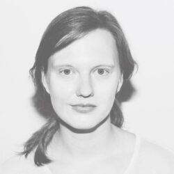 Portraitfoto von Antonia Gersch in hellem Shirt mit zurückgebundenen Haaren. Das Foto ist ein schwarz-weiß Portrait der Fotografin Katja Stempel.